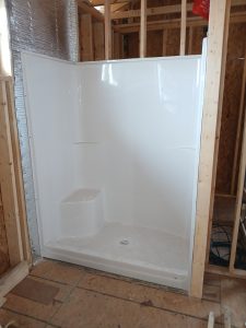 One-piece shower installation with built-in seat by Madison's Homes
