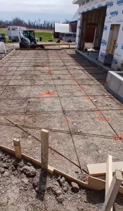 Concrete slab preparation with steel rebar reinforcement and formwork before pouring concrete by Madison’s Homes in the Cedar Rapids, Iowa area.