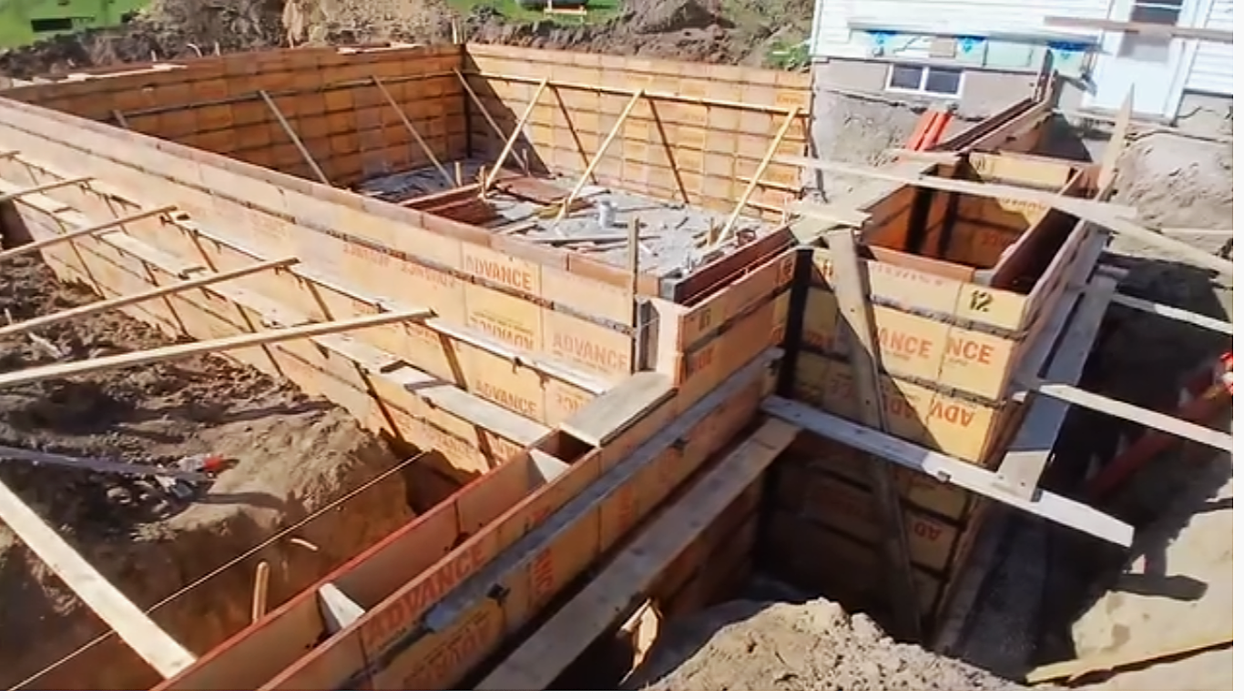Wooden poured concrete basement wall forms showing horizontal walers, diagonal bracing and steel rebar reinforcement by Madison's Homes in Cedar Rapids, Iowa.